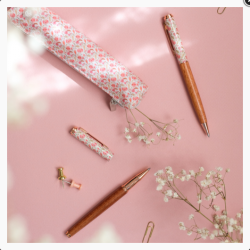 Stylo bille Bahia en bois, capuchon motif floral rose, ambiance fond rose, accessoires de papeterie.